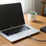 An external hard drive connected to a laptop on a desk, representing a local backup setup