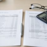 A person reviewing an itemized medical bill next to an insurance explanation of benefits statement on a table