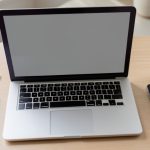 A person weighing options to resolve a money dispute at a desk with a laptop and paperwork, before considering small claims court